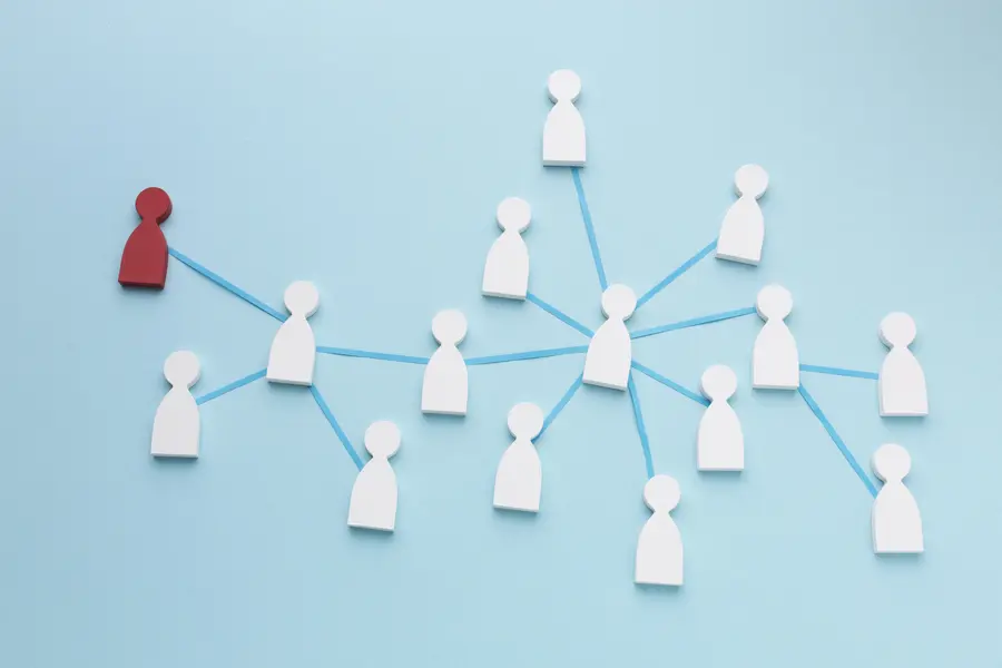 Mehrere Spielfiguren sind durch Fäden verbunden und bilden ein Netzwerk auf blauen Hintergrund