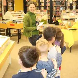 Kinder bilden eine Kette hinter einer Frau.