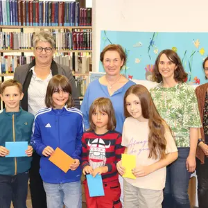 Gruppenbild mit vier Frauen im HIntergrund und vier Kindern im Vordergrund.