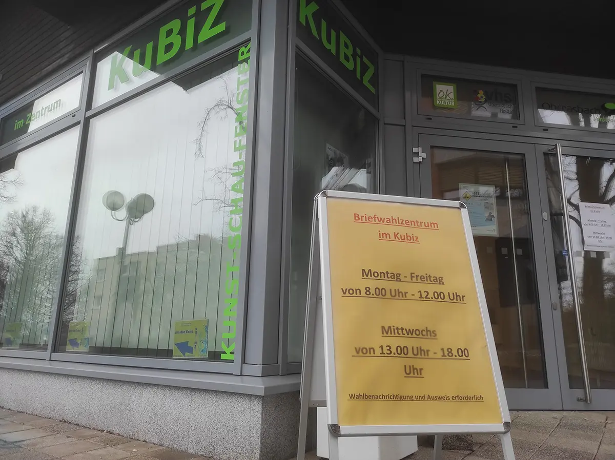 Schild vor einer Glasfront mit den Öffnungszeiten des Briefwahlzentrums.