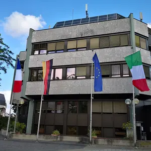 Rathaus mit französischer, deutscher, europäischer und italienischer Flagge geschmückt.