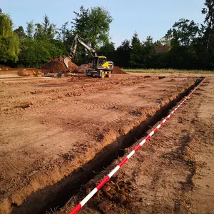 Bagger beim Erdaushub der Gräben für die Fundamente