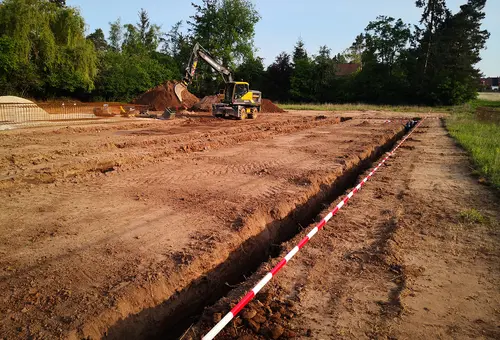 Bagger beim Erdaushub der Gräben für die Fundamente