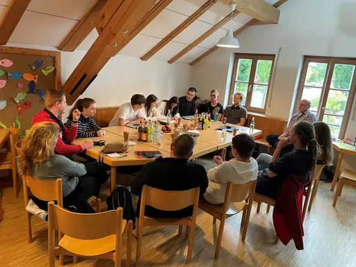 Eine Gruppe von Jugendlichen sitzt um einen Tisch herum