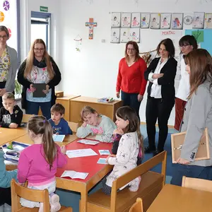 Sieben Frauen stehen um den Experimentiertisch herum, an dem acht Kinder Versuche machen.