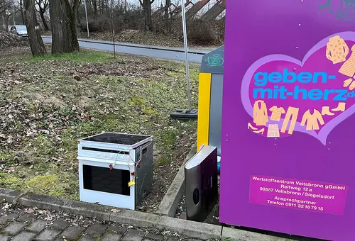 Illegal entsorgter Elektroherd neben einem Altkleidercontainer