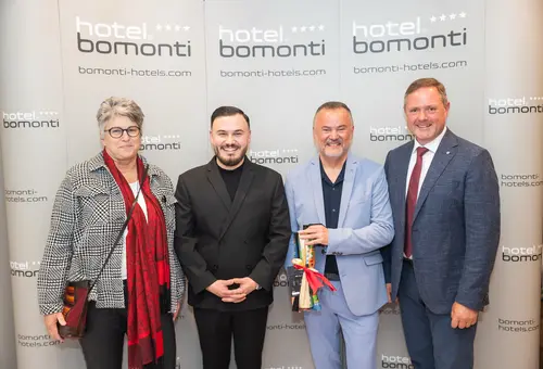 Mert Baydemir, Birgit Huber, Murat Baydemir und Bernd Obst vor einer Fotowand im Bomonti Hotel.