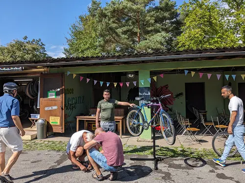 Mehrere Personen stehen um ein aufgebocktes Fahrrad im Innenhof des Jugendhauses.