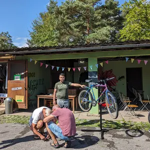 Mehrere Personen stehen um ein aufgebocktes Fahrrad im Innenhof des Jugendhauses.
