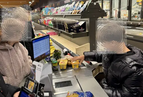 Jugendliche scannen Waren an einer Discounter-Kasse 