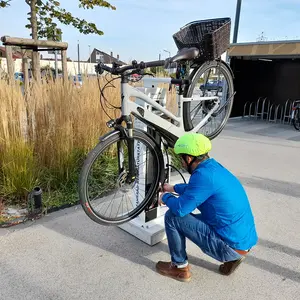 Ein Mann repariert sein Fahrrad an der Station