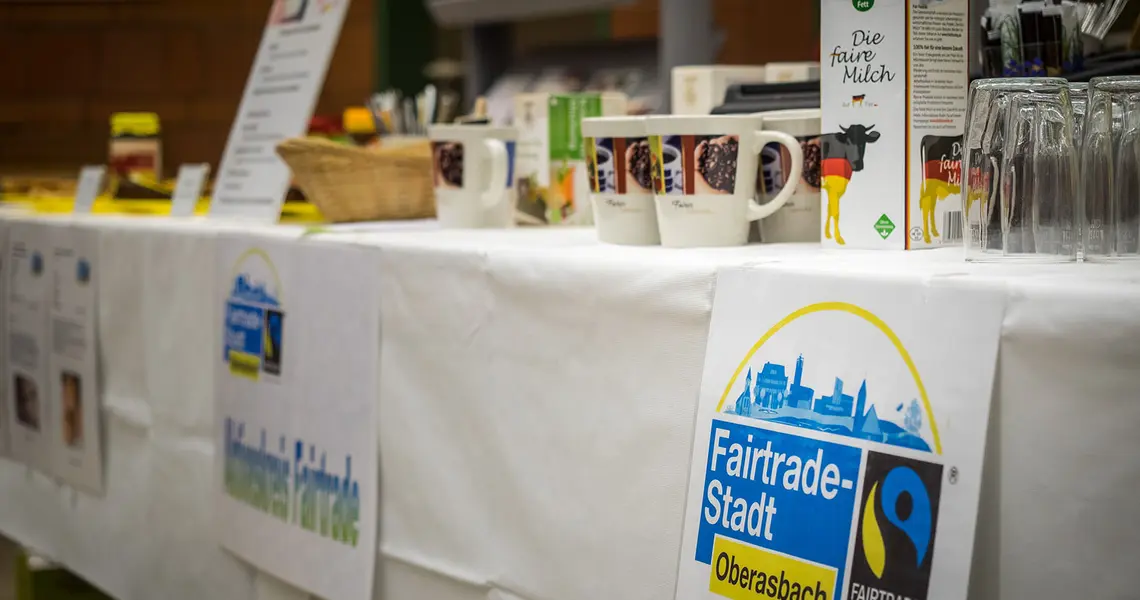 Fairtrade Produkte auf einem Tisch mit Fairtrade Logo Oberasbach im Vordergrund