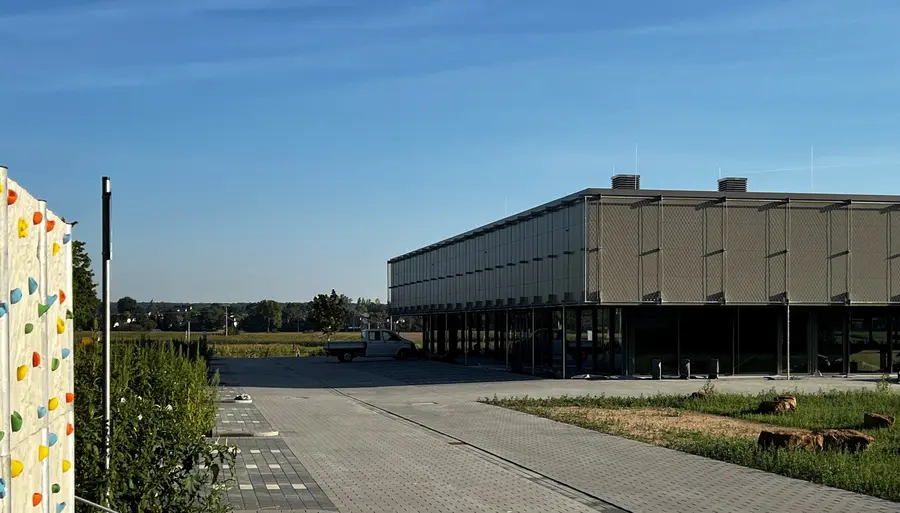 Blick auf die Asbachhalle mit kleiner Kletterwand im Vordergrund.