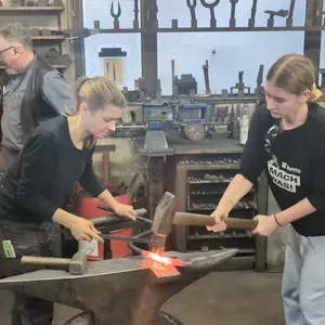 zwei Schülerinnen am Schmiedehammer 