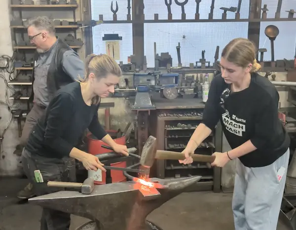 zwei Schülerinnen am Schmiedehammer 