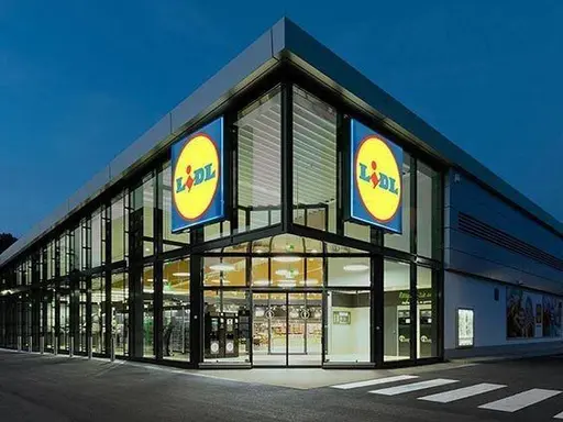 Beispielfoto des Eingangsbereiches einer Lidl-Filiale der aktuellen Generation mit vielen Glasfenstern.