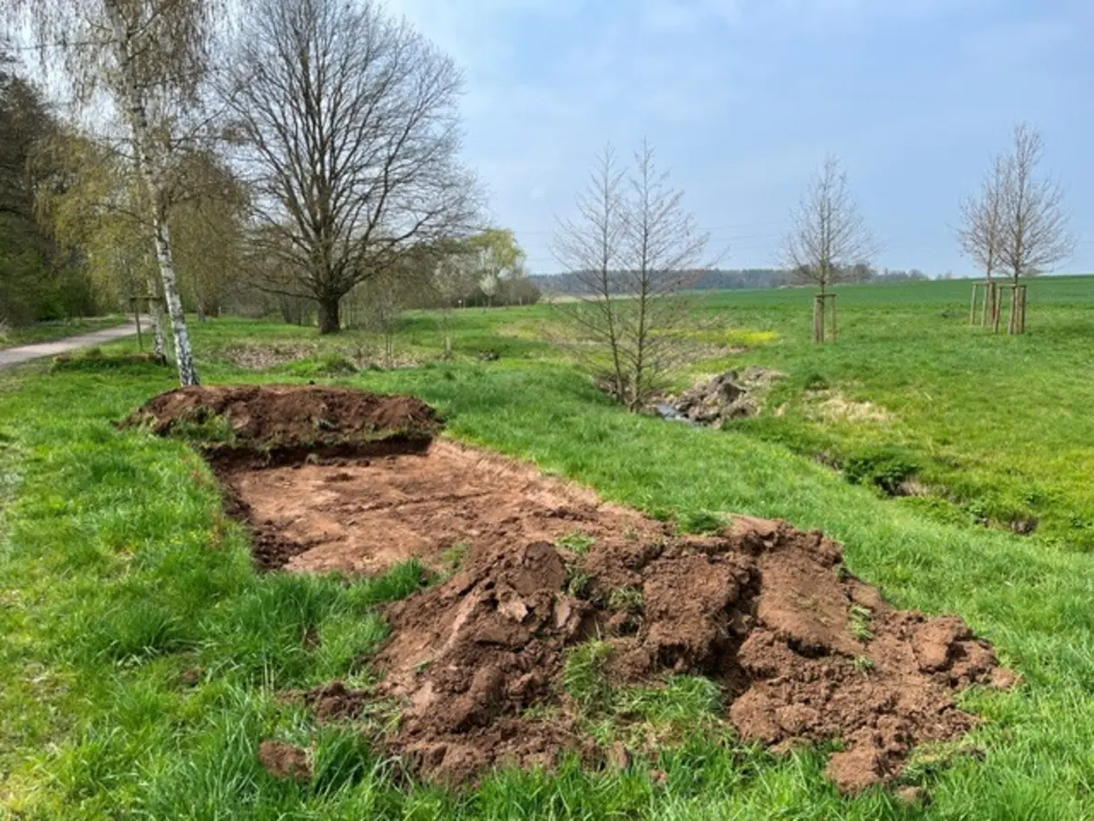 Eine Wiese, auf der ein breiter Streifen Boden freigelegt ist