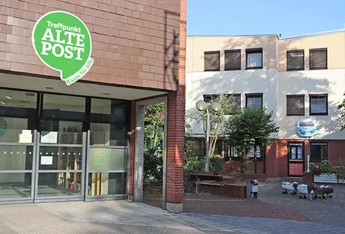 Backsteingebäude Am Rathaus 6 mit dem Schild "Treffpunkt Alte Post - Raum für alle" über dem Eingang.