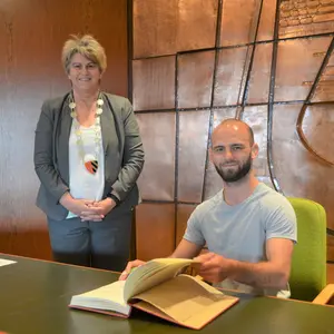 Ein Mann hat sich in das Goldene Buch eingetragen.