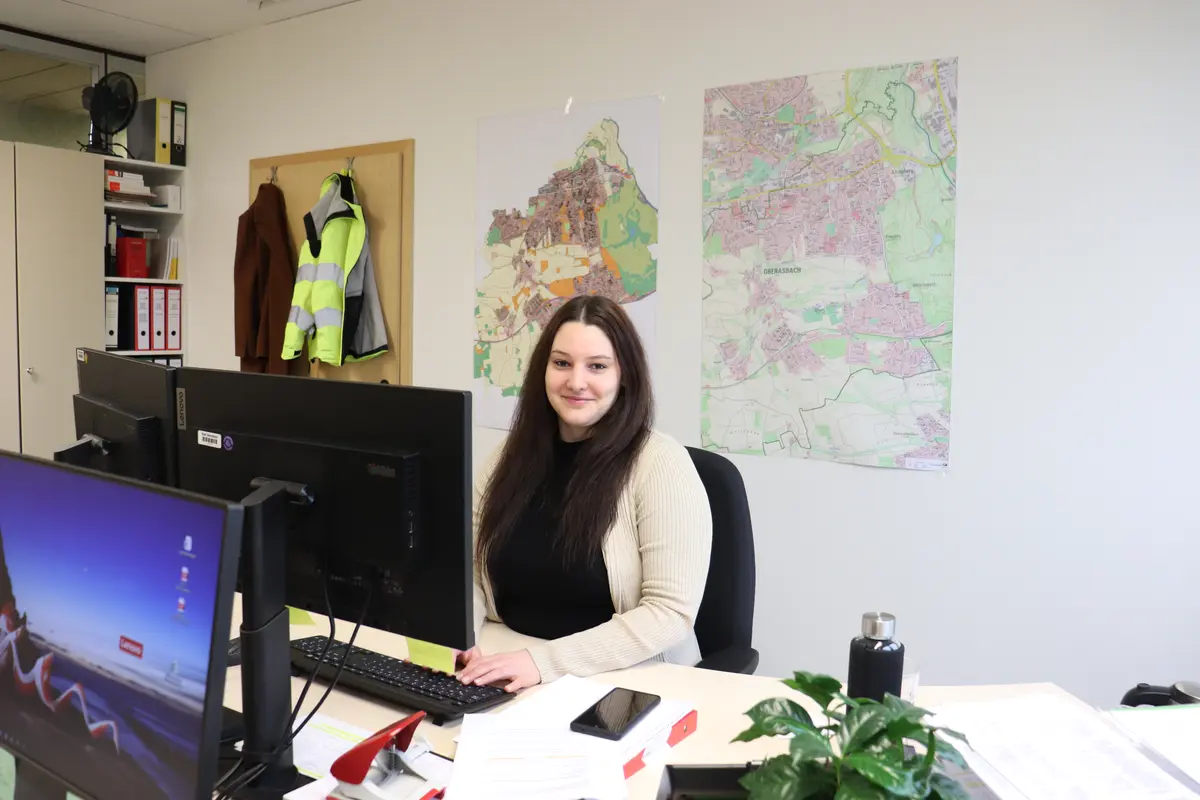 Alexandra Hetzer an ihrem Schreibtisch (Laptop; Karte im Hintergrund)