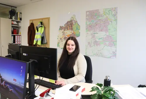 Alexandra Hetzer an ihrem Schreibtisch (Laptop; Karte im Hintergrund)