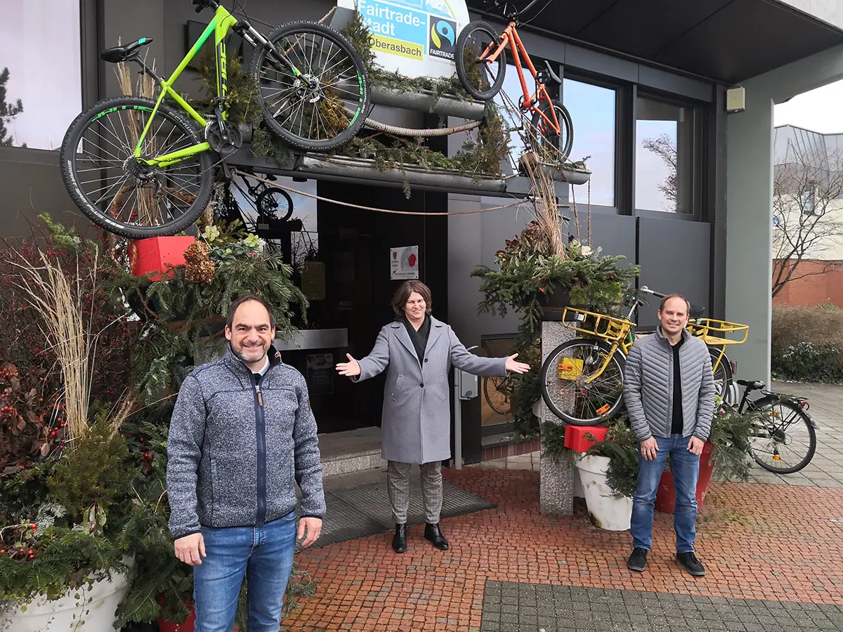 Erste Bürgermeisterin Birgit Huber steht mit den beiden Männern vor dem Rathaus und eutet einladend auf sie.Wolfstädter (links) und Daniel Morawietz.