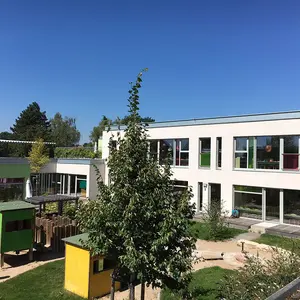 Blick vom Garten mit Spielgeräten auf das Gebäude
