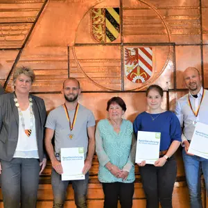 Acht Personen vor der Wand mit den Wappen der Stadt Oberasbach und des Landkreises Fürth