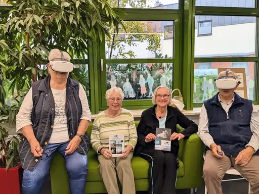 Vier ältere Herrschaften auf einem Sofa, zwei von ihnen tragen Virtual-Reality-Brillen