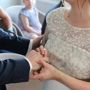 Die Braut steckt dem Bräutigam den Trauring an den Finger.