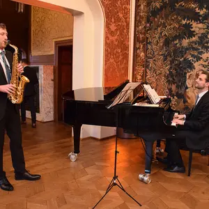 Ein Musiker am Flügel und einer am Saxophon.