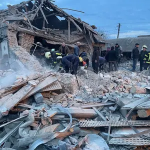 Zerstörtes Haus mit Feuerwehrleuten