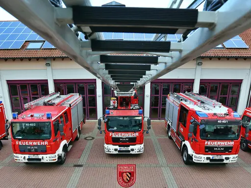 von der Spitze der Drehleiter blickt man auf die fünf Einsatzfahrzeuge der Feuerwehr