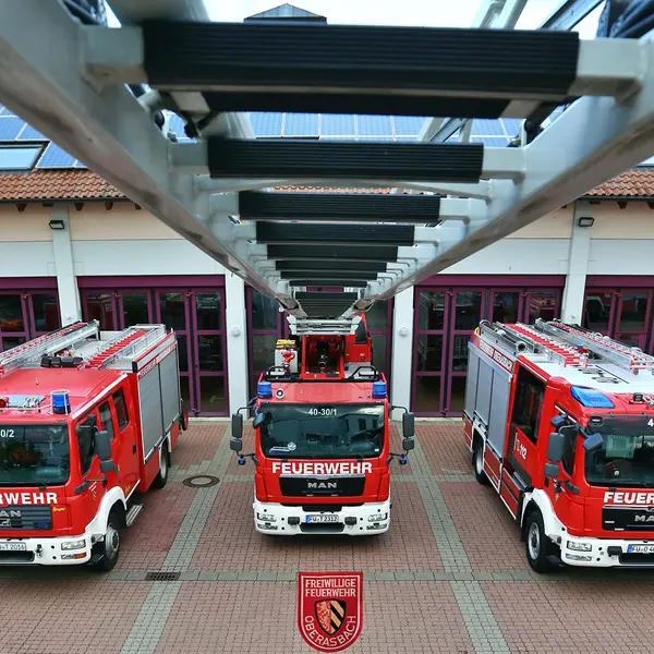 von der Spitze der Drehleiter blickt man auf die fünf Einsatzfahrzeuge der Feuerwehr
