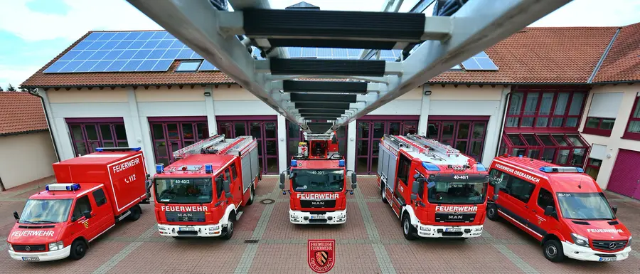 von der Spitze der Drehleiter blickt man auf die fünf Einsatzfahrzeuge der Feuerwehr