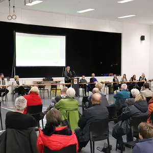 Eine Rednerin mit dem Publikum im Vordergrund