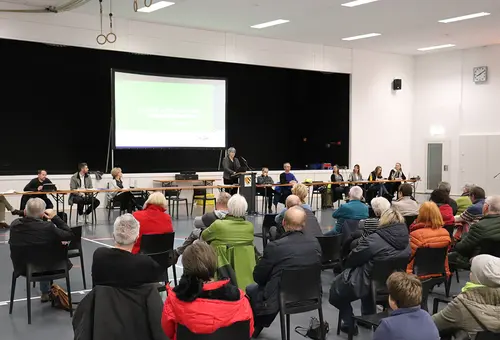 Eine Rednerin mit dem Publikum im Vordergrund