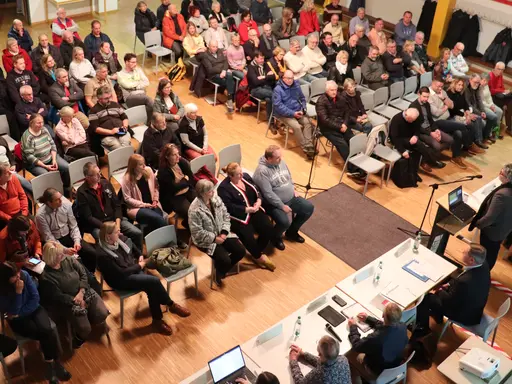 Blick von oben in die Aula der Grundschule Altenberg; unten rechts das Rednerpult und die Abteilungsleiter:innen