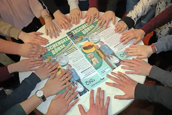 Helfende Hände im Kreis auf einer Tischplatte beim Handy-ABC