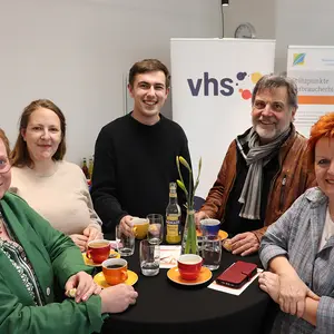 Zwei Männer und drei Frauen an einem Stehtisch