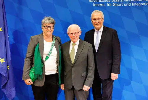 Zwei Männer und eine Frau im Anzug.