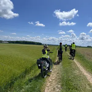 Radfahrer auf einem Feldweg unter blauem Himmel 