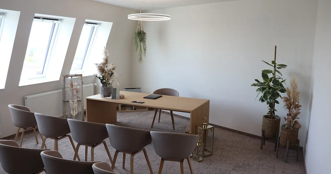 Blick in das Trauzimmer, im Hintergrund der Schreibtisch des Standesbeamten, davor die Stühle des Brautpaares und der Gäste.