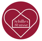 Logo Schillerstraße: dunkelroter Kreis, darin weiße Umrisse eines Herzens. Im Herz Umriss eines Hauses mit dem Wort Schillerstraße. 