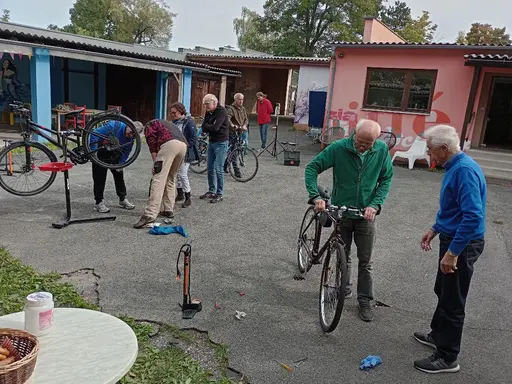 Im Innenhof des Jugendhauses stehen mehrere Personen mit Fahrrädern 