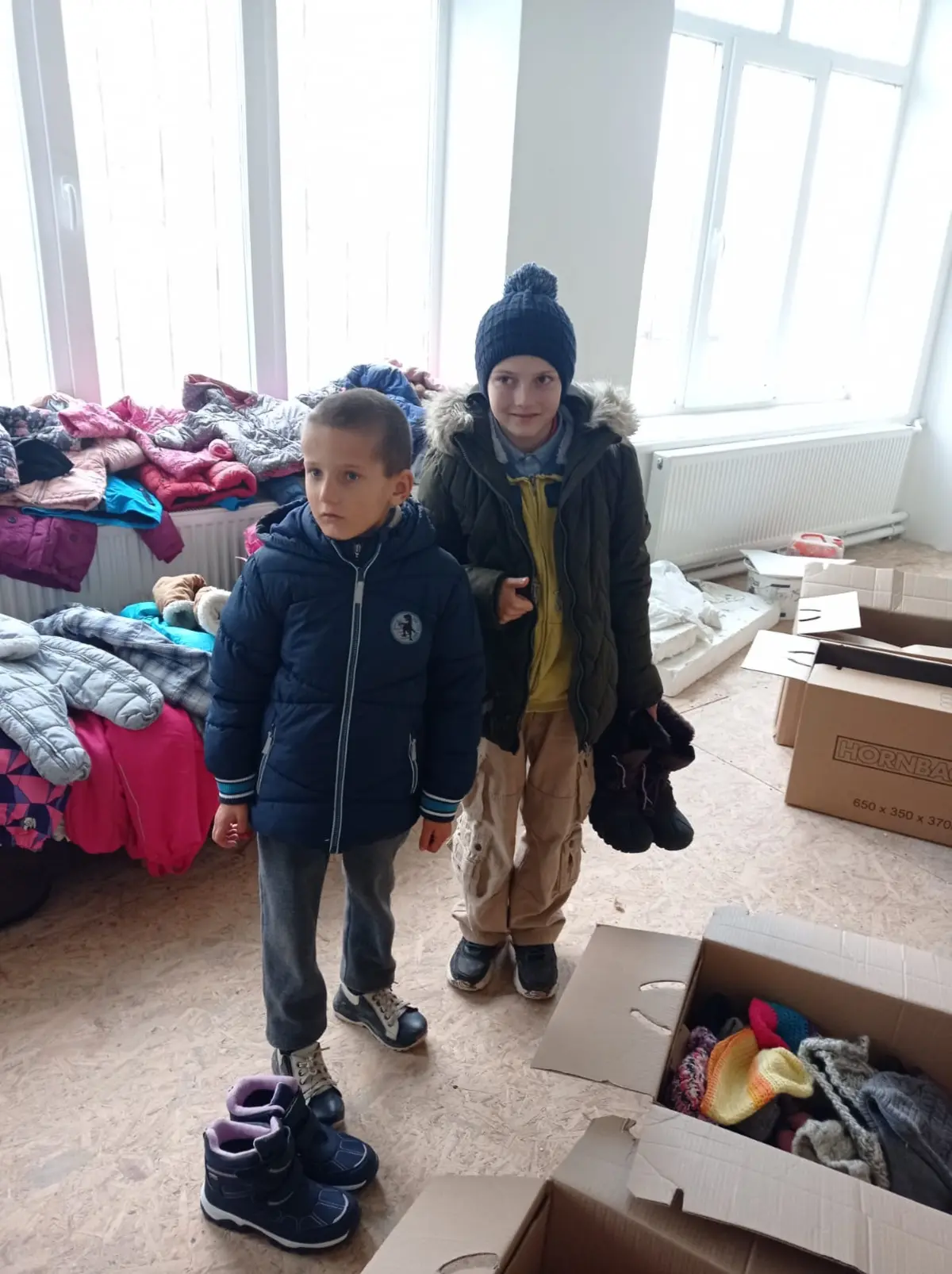 Kinder in einer Ausgabestelle für gespendete Kleidung