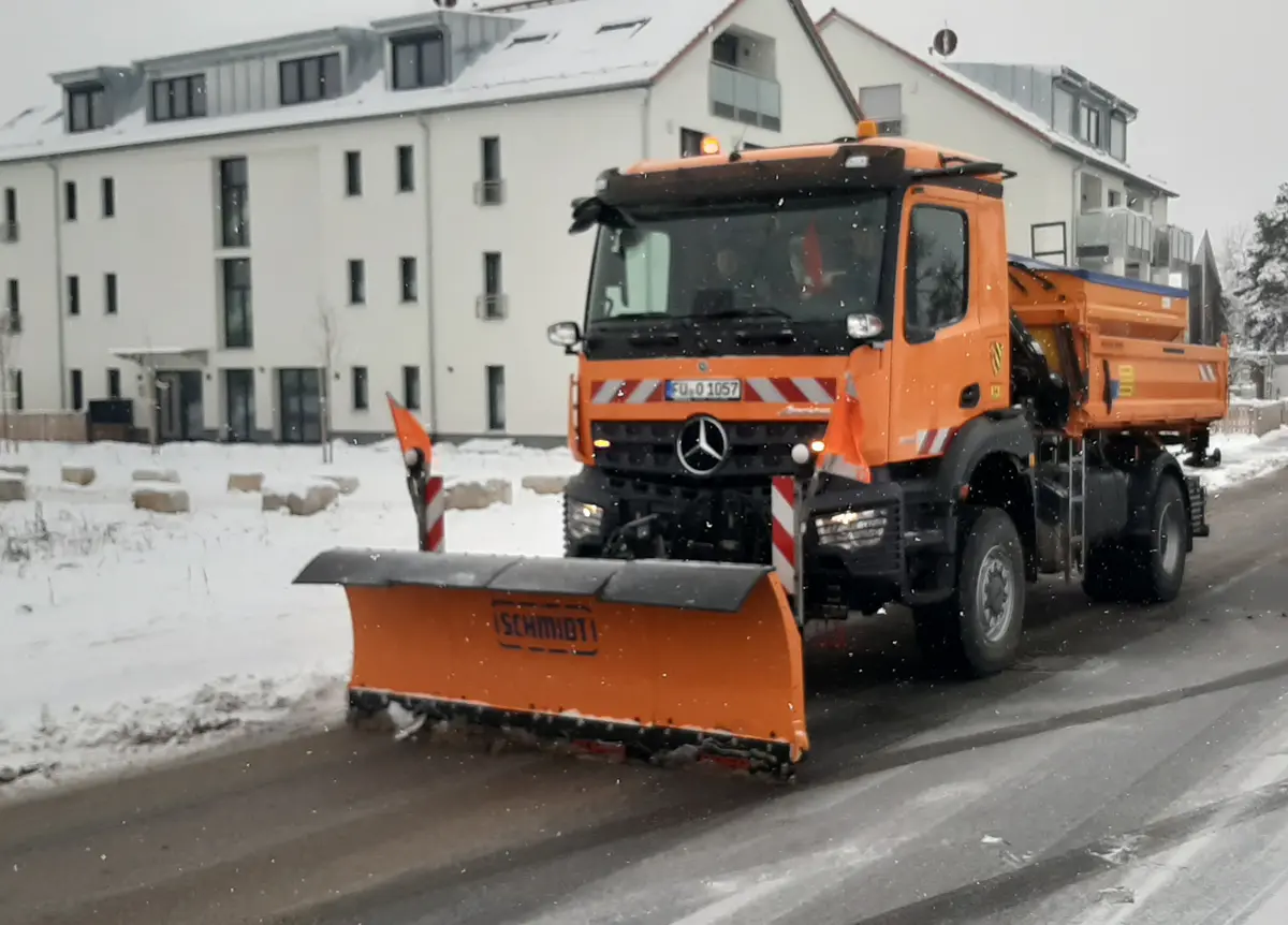 Oranger LKW des Bauhofes mit Schneeschild beim Winterdiensteinsatz im Ortskern von Oberasbach