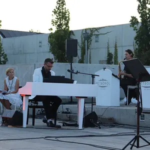 Bandleader Timm Freyer am Piano, im Hintergrund links seine Frau und Moderatorin Ulrike Freier.