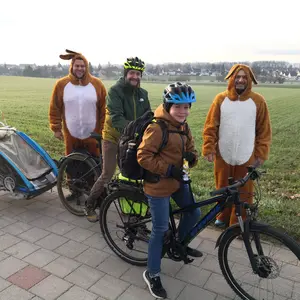 zwei Männer im Plüschhasenkostüm. zwischen ihnen ein Mann mit Fahrrad und Kinderanhänger und ein Junge auf einem Rad © Stadt Oberasbach