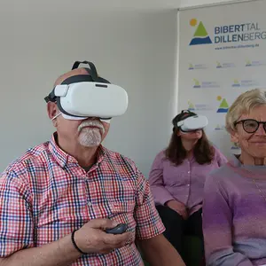 Ein Mann und eine Frau tragen eine VR-Brille, daneben eine weitere Frau.
